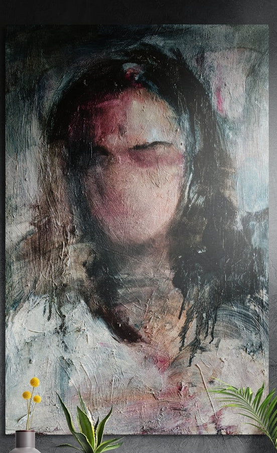 Blurred woman portrait brushed aluminum wall art on a dark textured wall above yellow flowers and potted plants