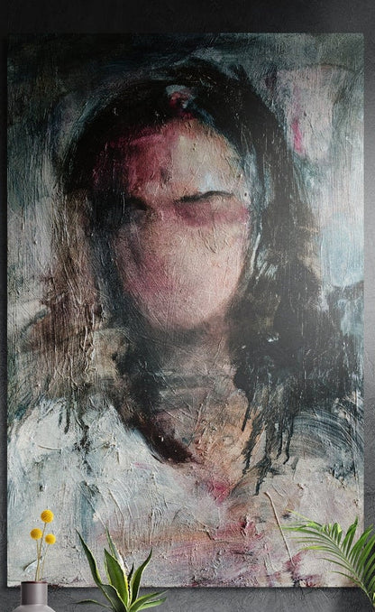 Blurred woman portrait brushed aluminum wall art on a dark textured wall above yellow flowers and potted plants