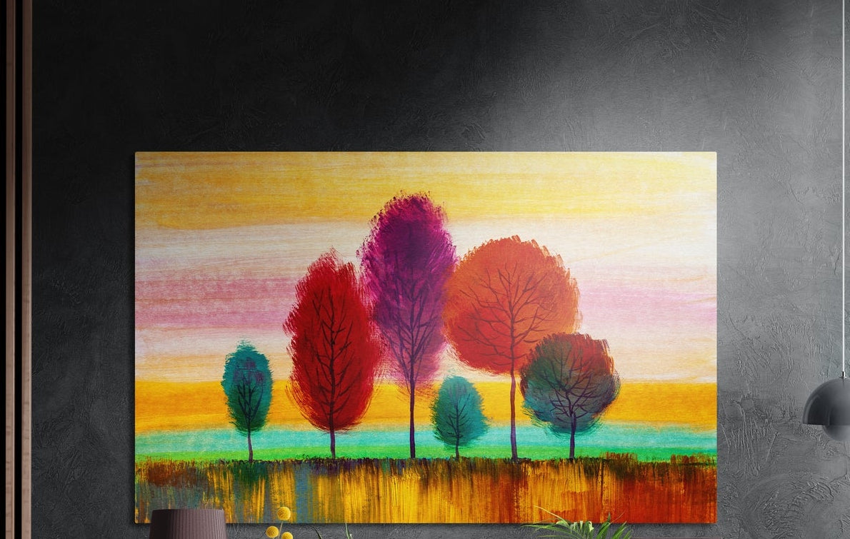 Red and purple trees on a golden field brushed aluminum wall art on a dark textured wall above potted plants