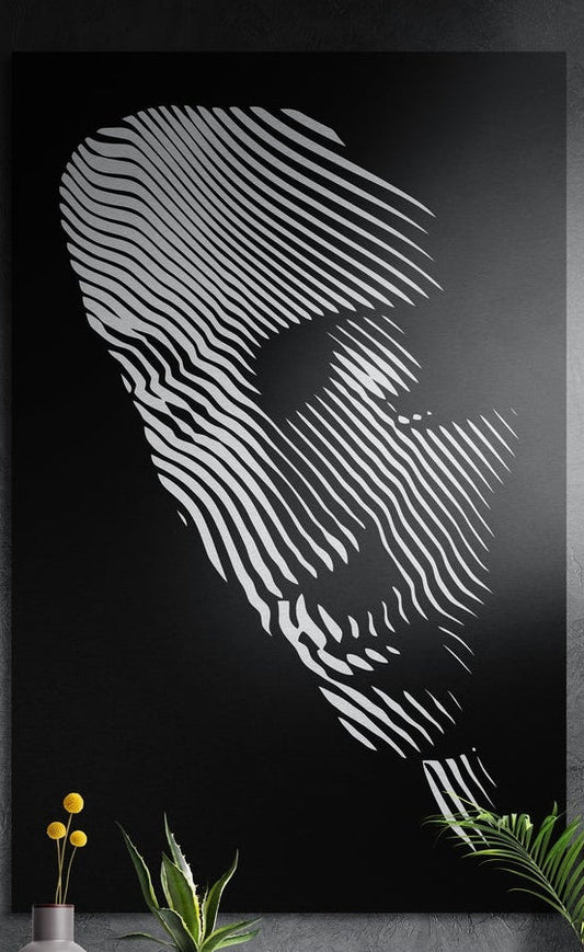 Black and white striped line face brushed aluminum wall art hung on a dark textured wall above potted plants