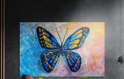 Blue and yellow butterfly on a pastel textured background, brushed aluminum wall art on a gray wall above yellow flowers