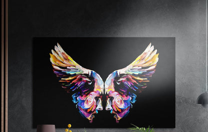Rainbow wings made of two mirrored painted faces on black, brushed aluminum wall art above a wooden sideboard