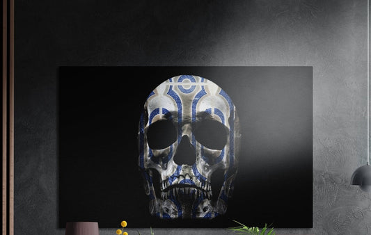 Blue and white pattern skull on black brushed aluminum wall art on a dark textured wall above potted plant tops