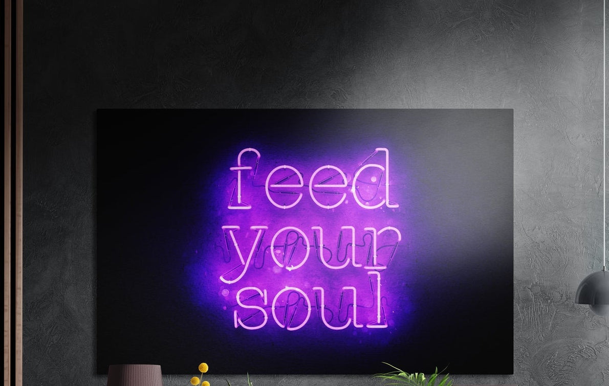 Feed your soul purple neon text brushed aluminum wall art on a dark gray concrete wall