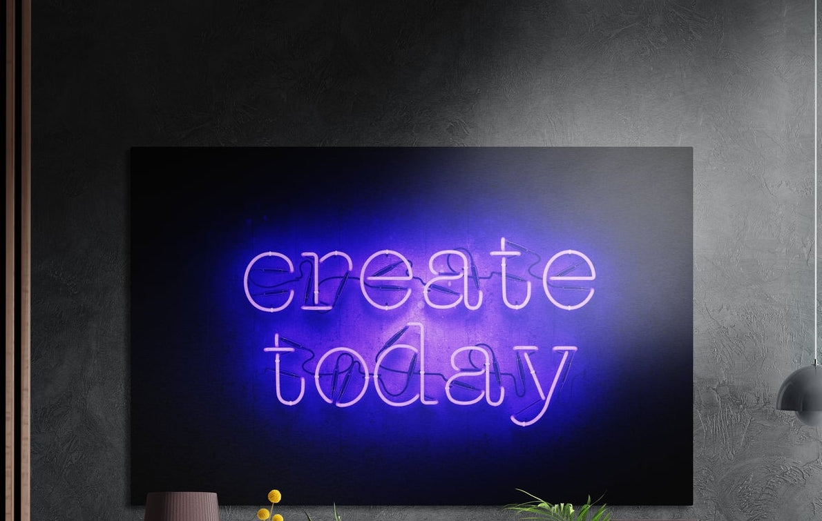 Create today purple neon text brushed aluminum wall art on a dark textured wall above a lamp and yellow flowers