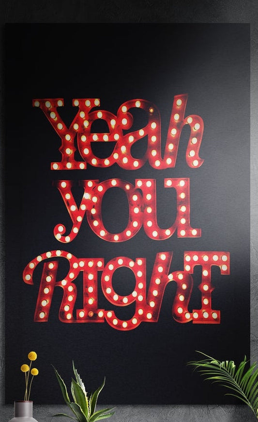 Red marquee lights brushed aluminum wall art on a dark textured wall behind a vase and potted plants