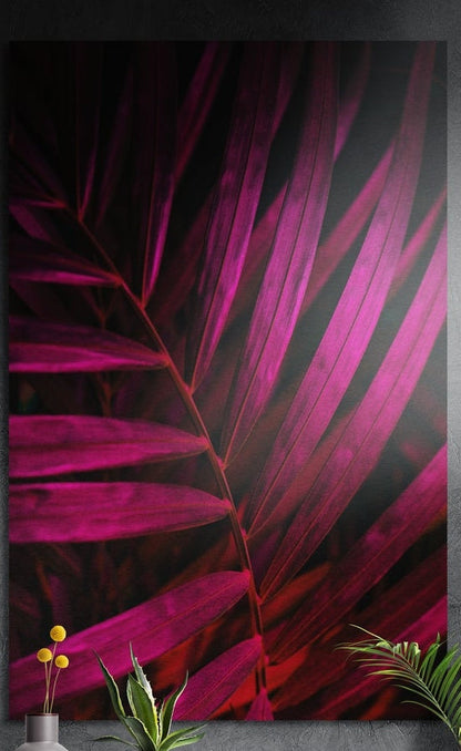 Magenta palm leaf brushed aluminum wall art on a dark textured wall behind potted plants
