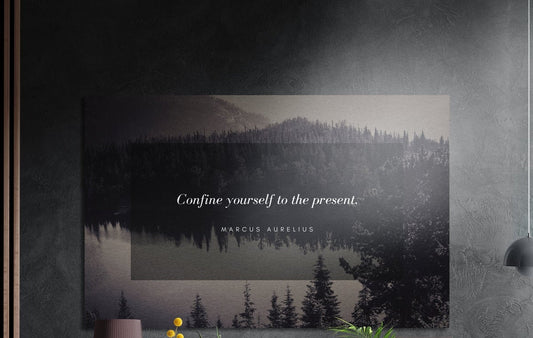 Present moment quote over a forest lake brushed aluminum wall art on a dark textured wall above a lamp and yellow flowers