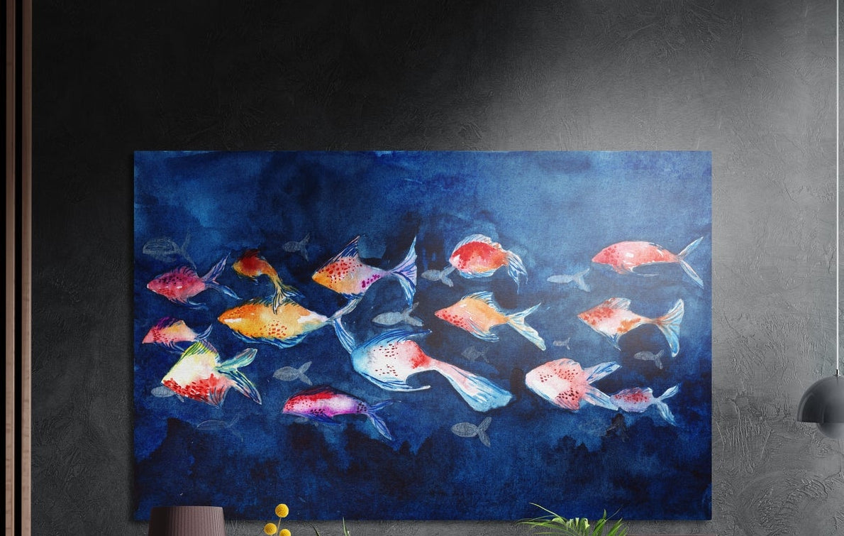 Colorful fish school on deep blue brushed aluminum wall art on a dark textured wall, a lamp and plant tops below