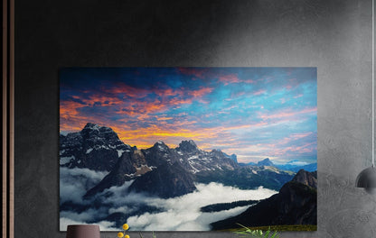 Mountain peaks brushed aluminum wall art on a dark gray wall above a sideboard with a vase and plants