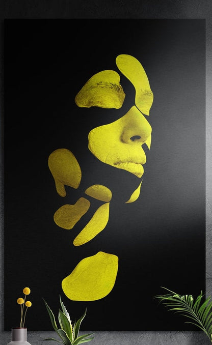 Yellow fragmented face brushed aluminum wall art on a dark textured wall above yellow flowers and potted plants