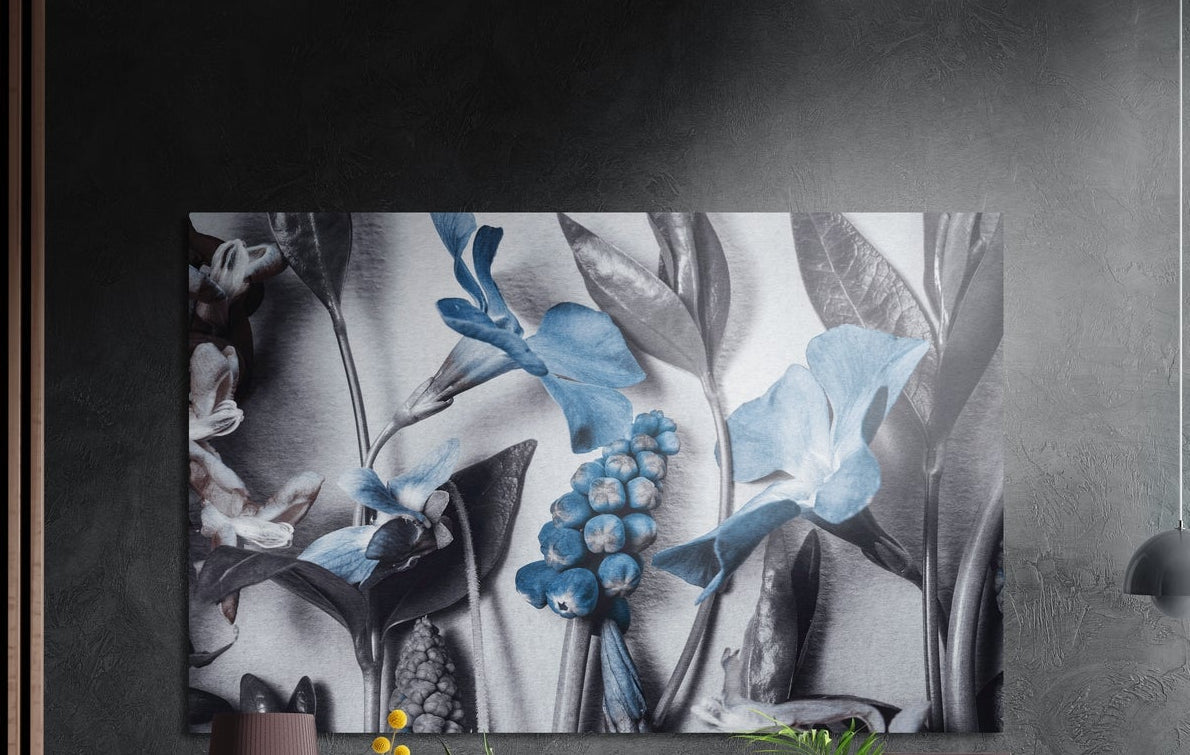 Steel blue blooms among gray foliage, brushed aluminum wall art on a dark gray wall beside a black wall lamp