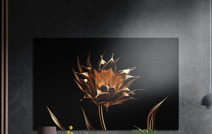 Golden flower on a black background, brushed aluminum wall art on a dark gray wall beside a black wall lamp