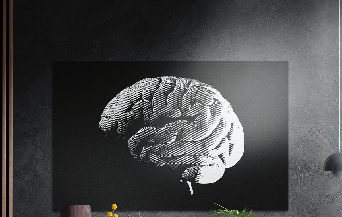 White halftone brain on a black background, brushed aluminum wall art on a dark gray wall above a sideboard