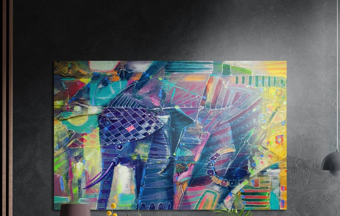 Abstract patchwork elephant in turquoise, violet and yellow, brushed aluminum wall art on a gray wall above a vase