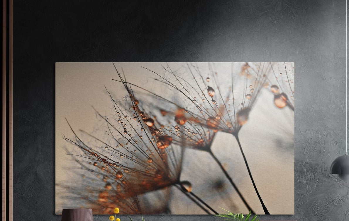 Dandelion seeds with water drops brushed aluminum wall art on a dark wall above a sideboard with yellow flowers