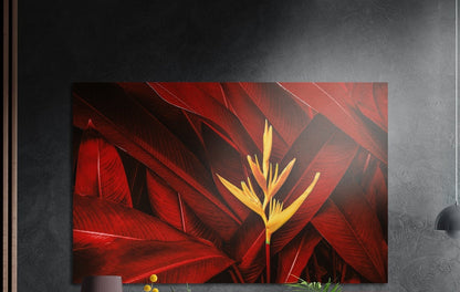 Crimson tropical leaves with a yellow bloom, brushed aluminum wall art on a dark gray wall beside a black wall lamp