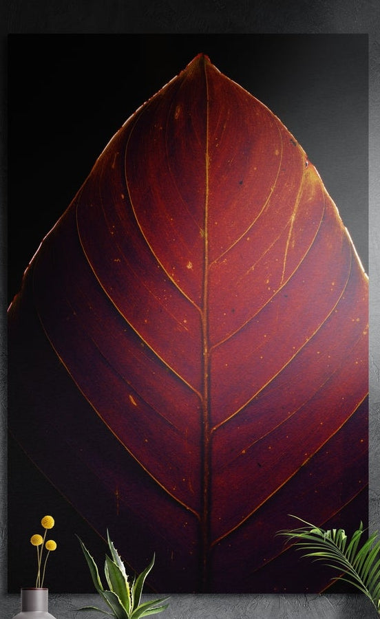 Glowing red leaf with gold veins, brushed aluminum wall art on a dark gray wall behind yellow billy buttons and plants