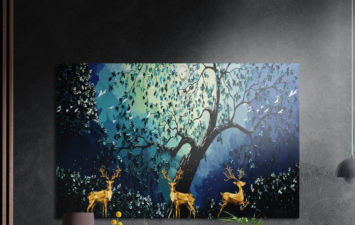 Three golden geometric deer under a teal-leaved tree and glowing blue sky, brushed aluminum wall art on a dark wall
