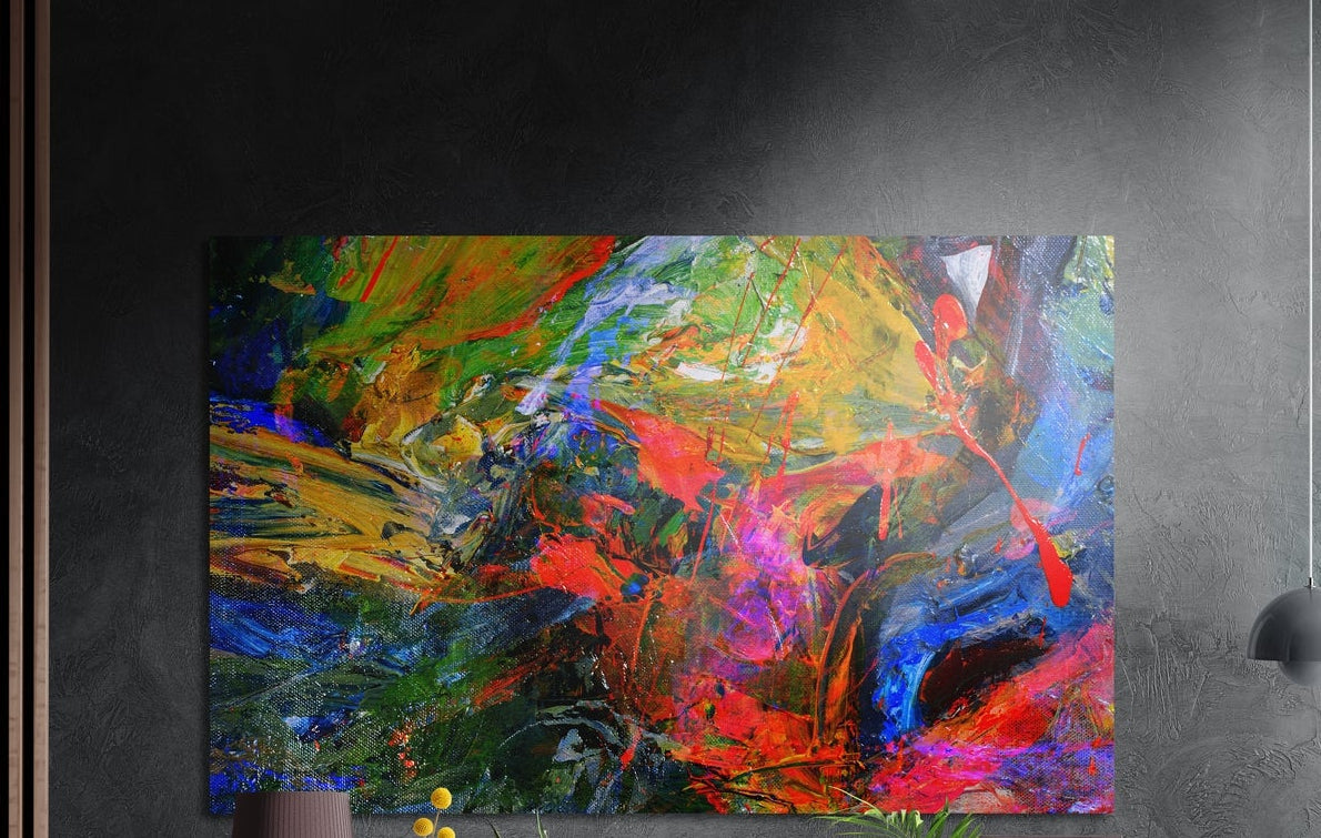 Bold red, yellow, green and blue abstract paint strokes, brushed aluminum wall art above a wooden sideboard