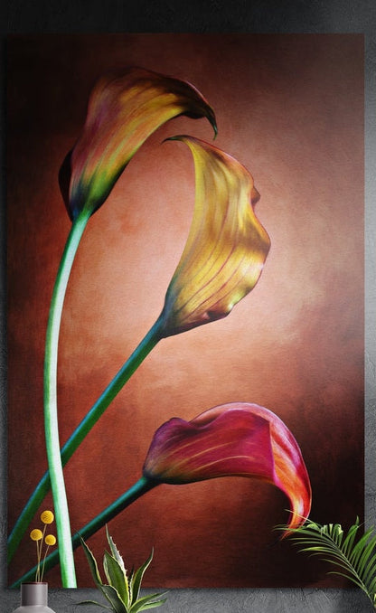 Three golden and coral calla lilies on a warm brown background, brushed aluminum wall art above a sideboard