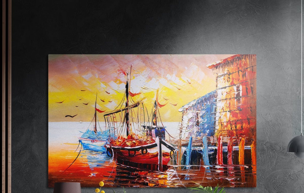 Fishing boats at a harbor sunset brushed aluminum wall art on a dark textured wall, a lamp and plant tops below