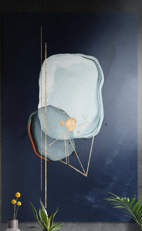 Pale blue abstract shapes with thin gold lines on navy, tall brushed aluminum wall art on a dark wall with leaves below