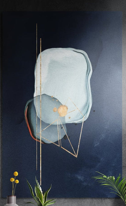 Pale blue abstract shapes with thin gold lines on navy, tall brushed aluminum wall art on a dark wall with leaves below