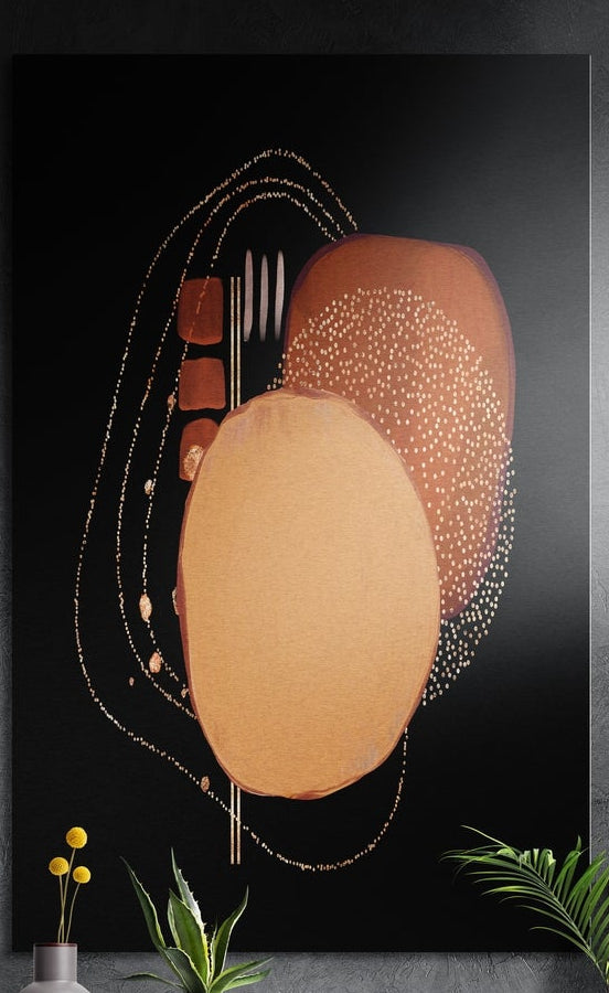 Copper ovals with gold dots on black brushed aluminum wall art on a dark wall behind yellow flowers and green plants