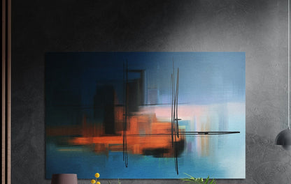 Orange and blue blurred abstract brushed aluminum wall art on a dark textured wall