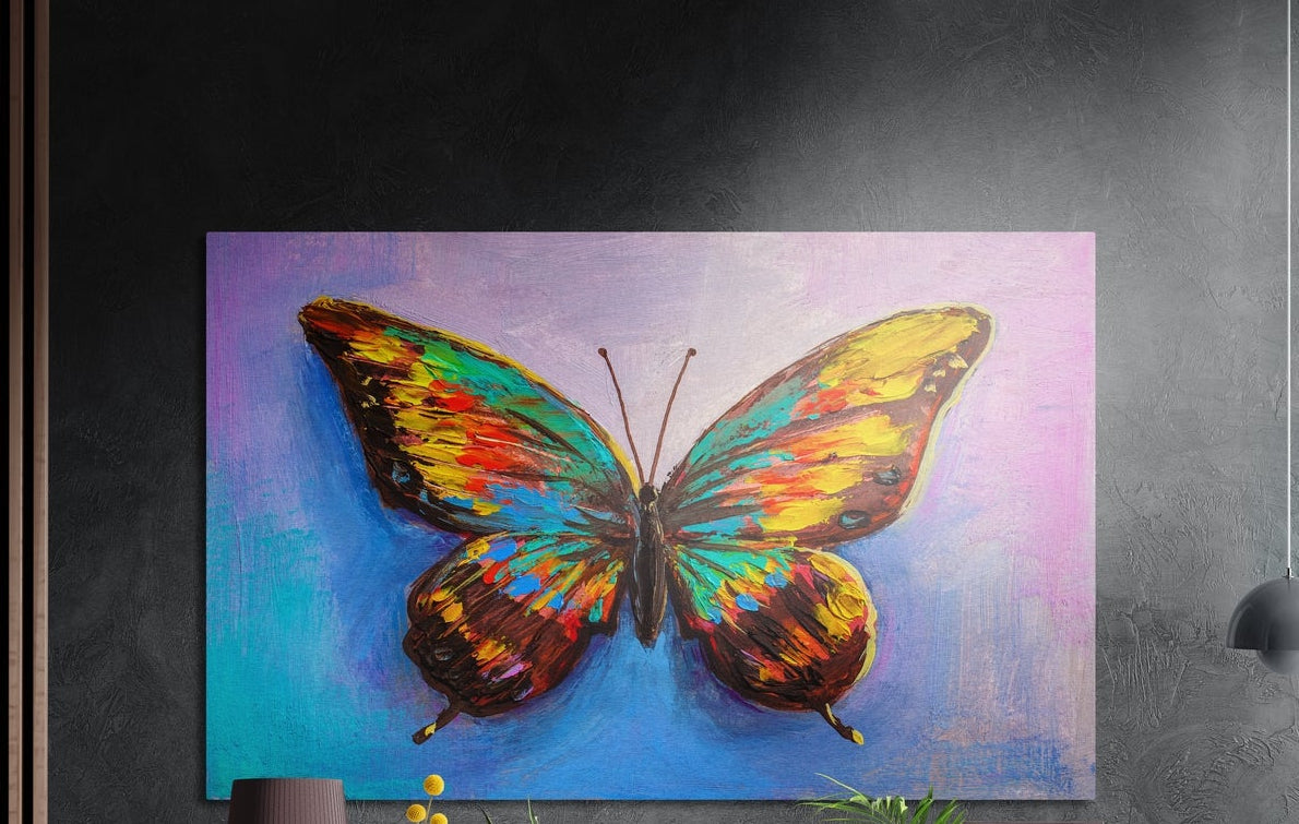 Rainbow butterfly on a blue and lilac background, brushed aluminum wall art on a gray wall above a vase and a plant