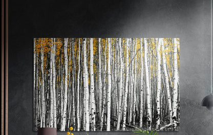 Yellow birch forest brushed aluminum wall art on a dark gray wall above a sideboard with a vase and plants