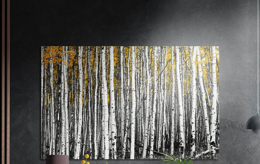 Yellow birch forest brushed aluminum wall art on a dark gray wall above a sideboard with a vase and plants