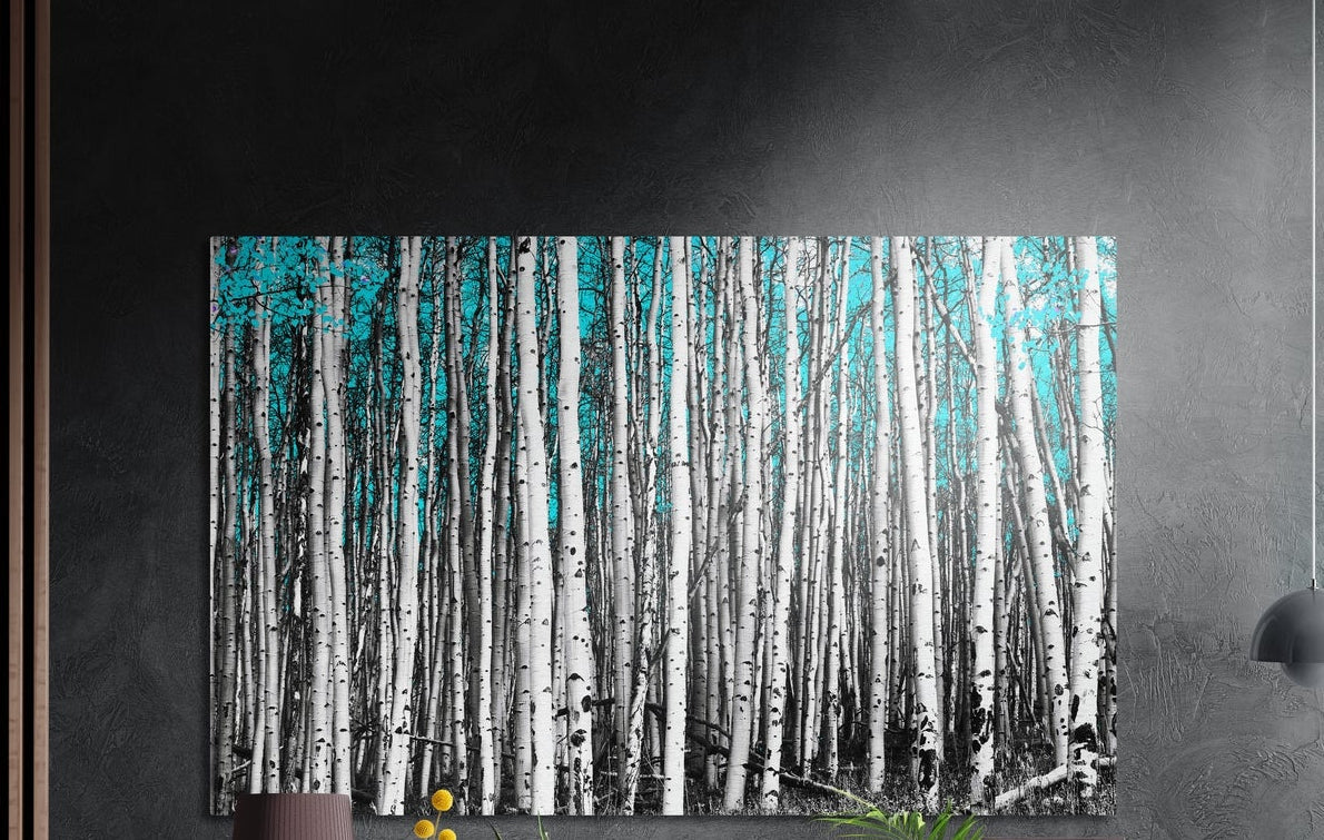 Turquoise birch forest brushed aluminum wall art on a dark gray wall above a sideboard with a vase and plants