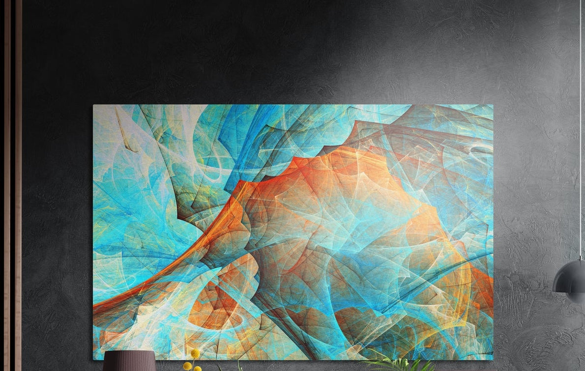 Turquoise and orange abstract brushed aluminum wall art on a dark gray wall beside a black wall lamp