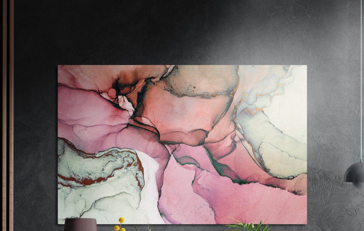 Blush pink and sage watercolor marble brushed aluminum wall art on a dark wall above the tips of potted plants