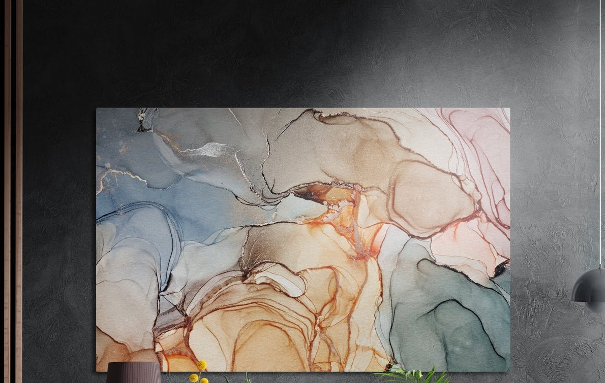Peach and teal alcohol ink marble brushed aluminum wall art on a dark textured wall above a vase and plants