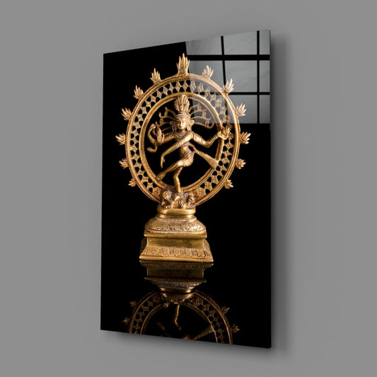 Brass dancing Shiva statue glass wall art on a gray wall, angled to show the glossy front