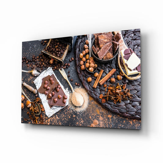 Kitchen glass wall art of dark, milk and white chocolate pieces with hazelnuts, cinnamon sticks and coffee beans on slate