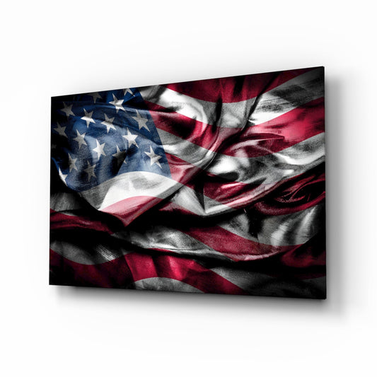 American flag in silky folds with white stars on navy and muted crimson stripes in deep shadow, on glass