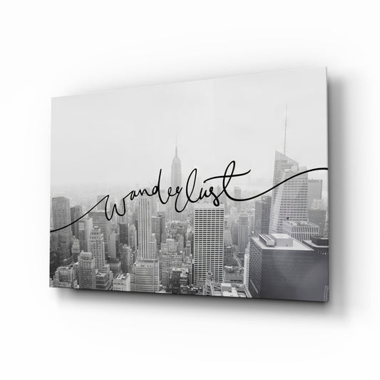 Black and white New York skyline glass wall art with the word wanderlust written in flowing black script across hazy towers