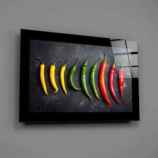 Chili peppers row glass wall art angled against a dark gray backdrop