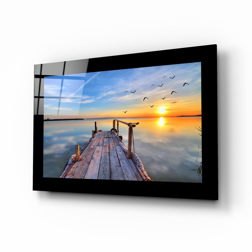 Reed-framed pier sunset glass wall art in tangerine and cobalt