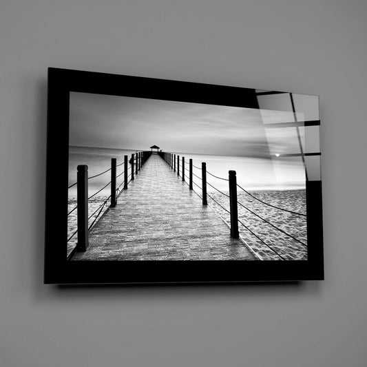 Black and white rope rail beach pier glass wall art with a black border hung on a plain gray wall