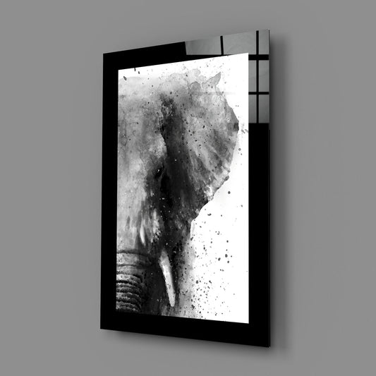 Black and white watercolor elephant glass wall art on a plain gray wall
