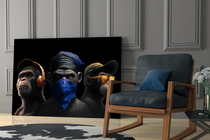 Three monkeys glass wall art above a blue armchair and a wooden rocking chair
