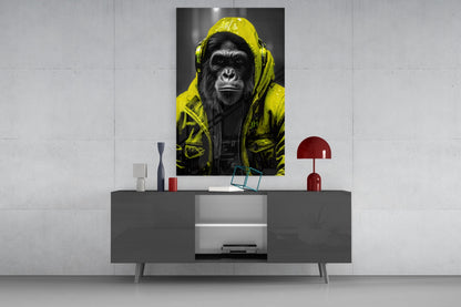 Yellow rain hood gorilla glass wall art on a concrete wall above a gray sideboard with small decor