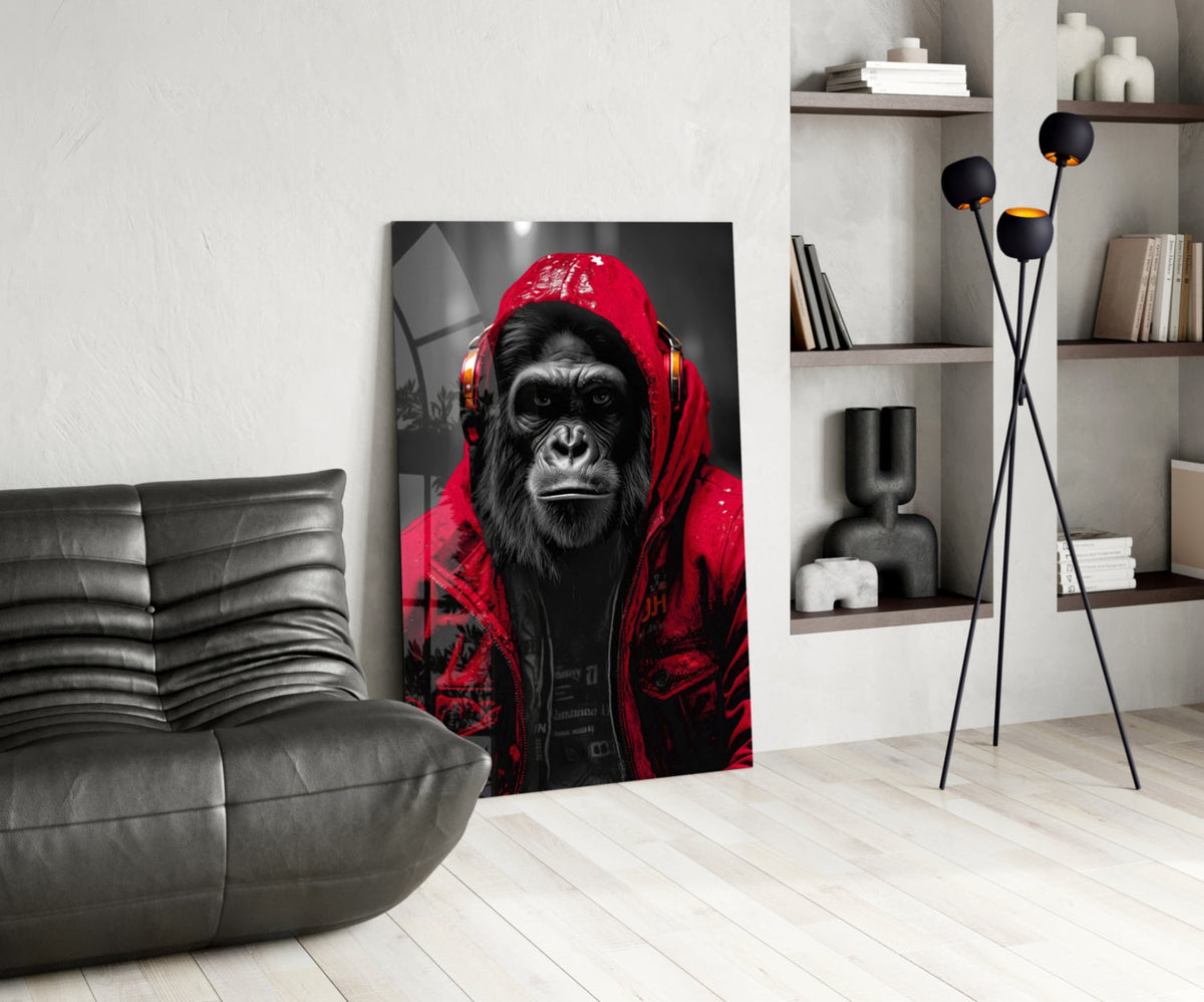 Red rain hood gorilla glass wall art leaning beside a black leather lounge chair and shelves