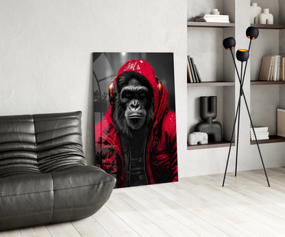 Red rain hood gorilla glass wall art leaning beside a black leather lounge chair and shelves