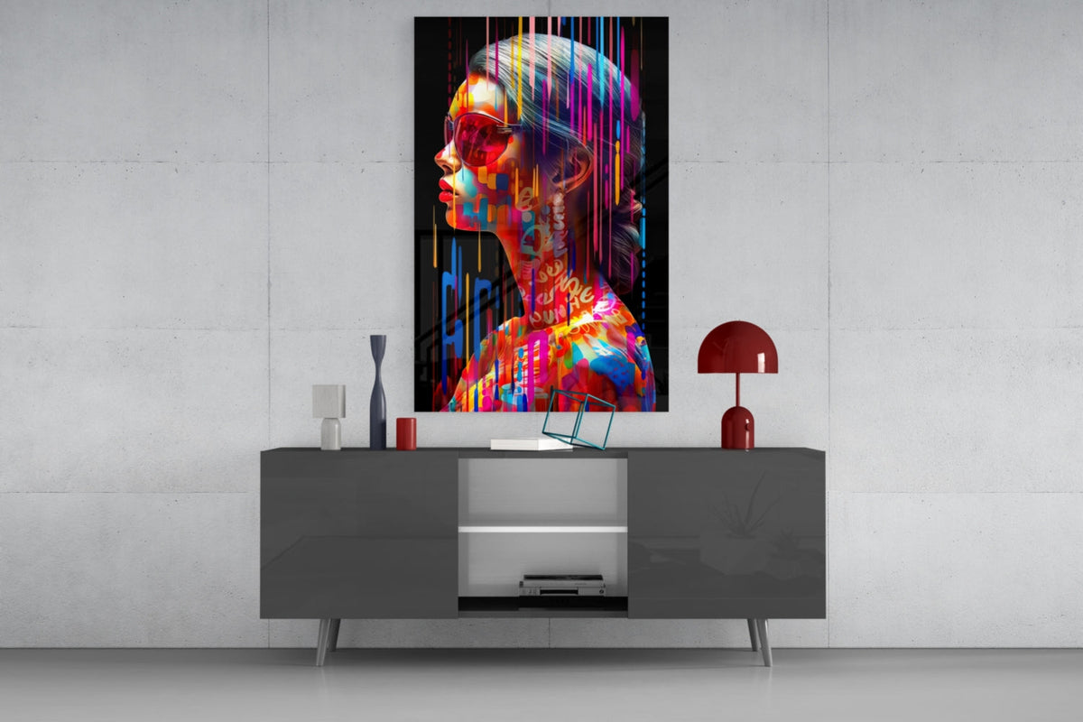 Rainbow drip woman in profile glass wall art above a gray sideboard with a red lamp on a concrete wall